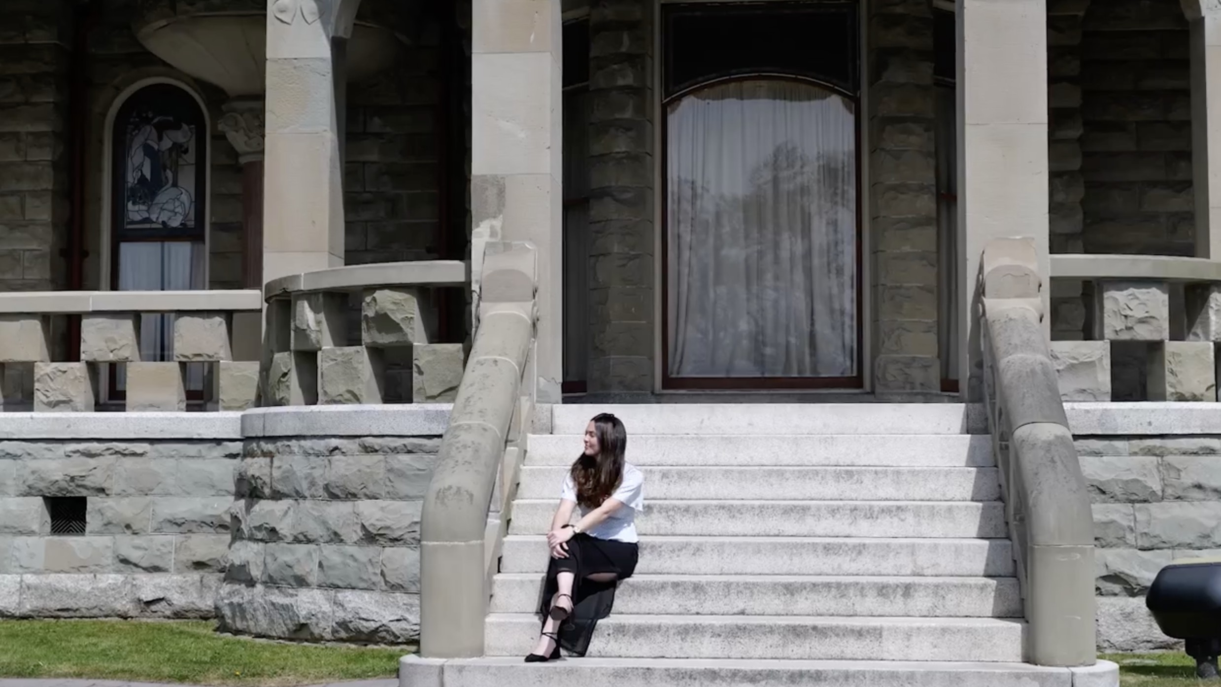 Hannah seated on the steps of a Victoria heritage home